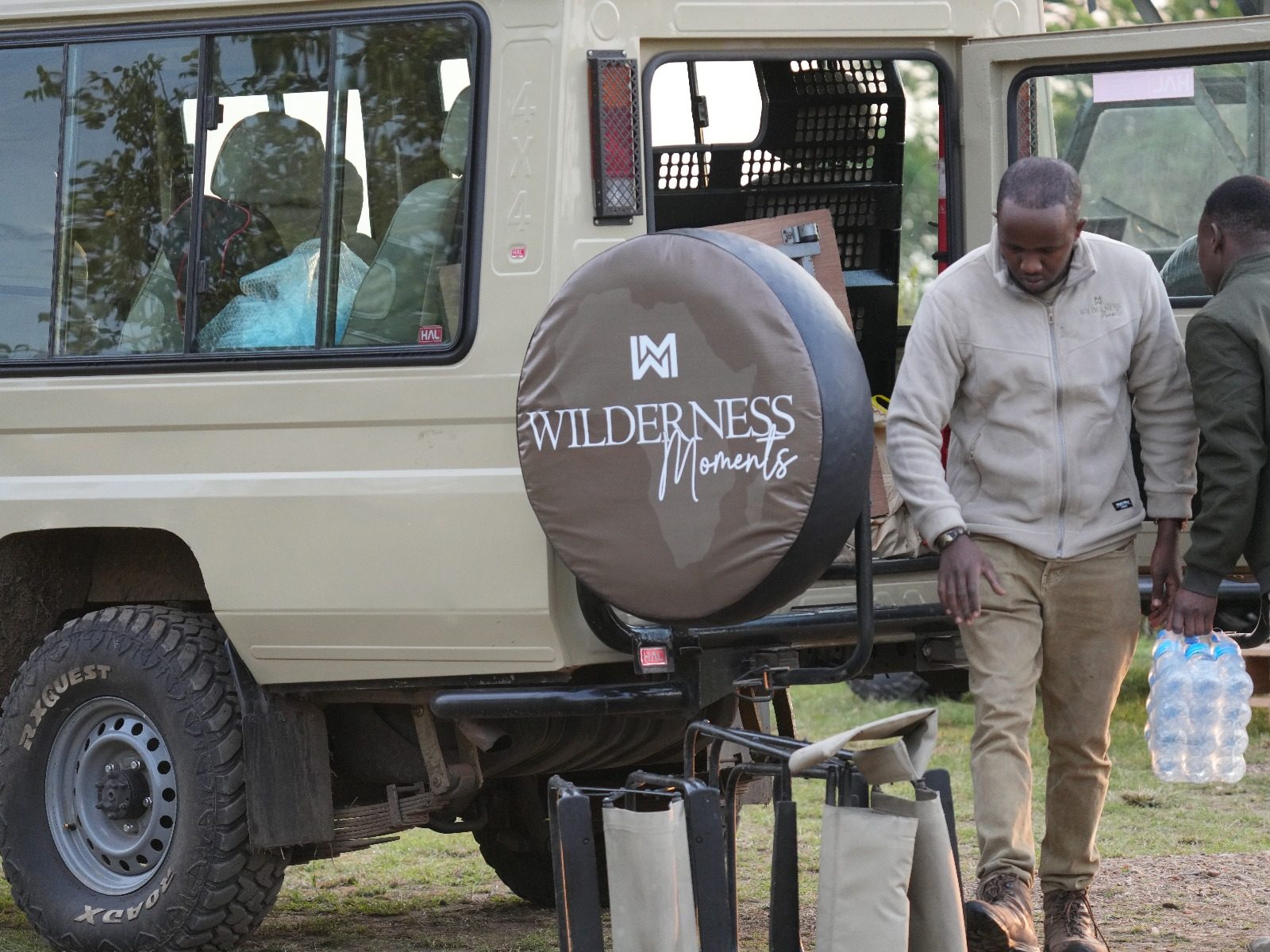 Wilderness Moments crew loading drinking water onto the safari vehicle